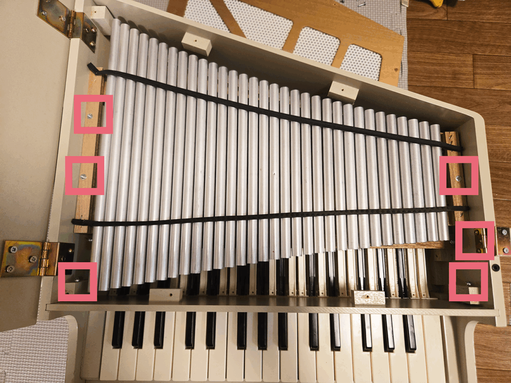 KAWAIミニピアノの分解途中。鉄パイプや蝶番のネジ位置を示した写真。
